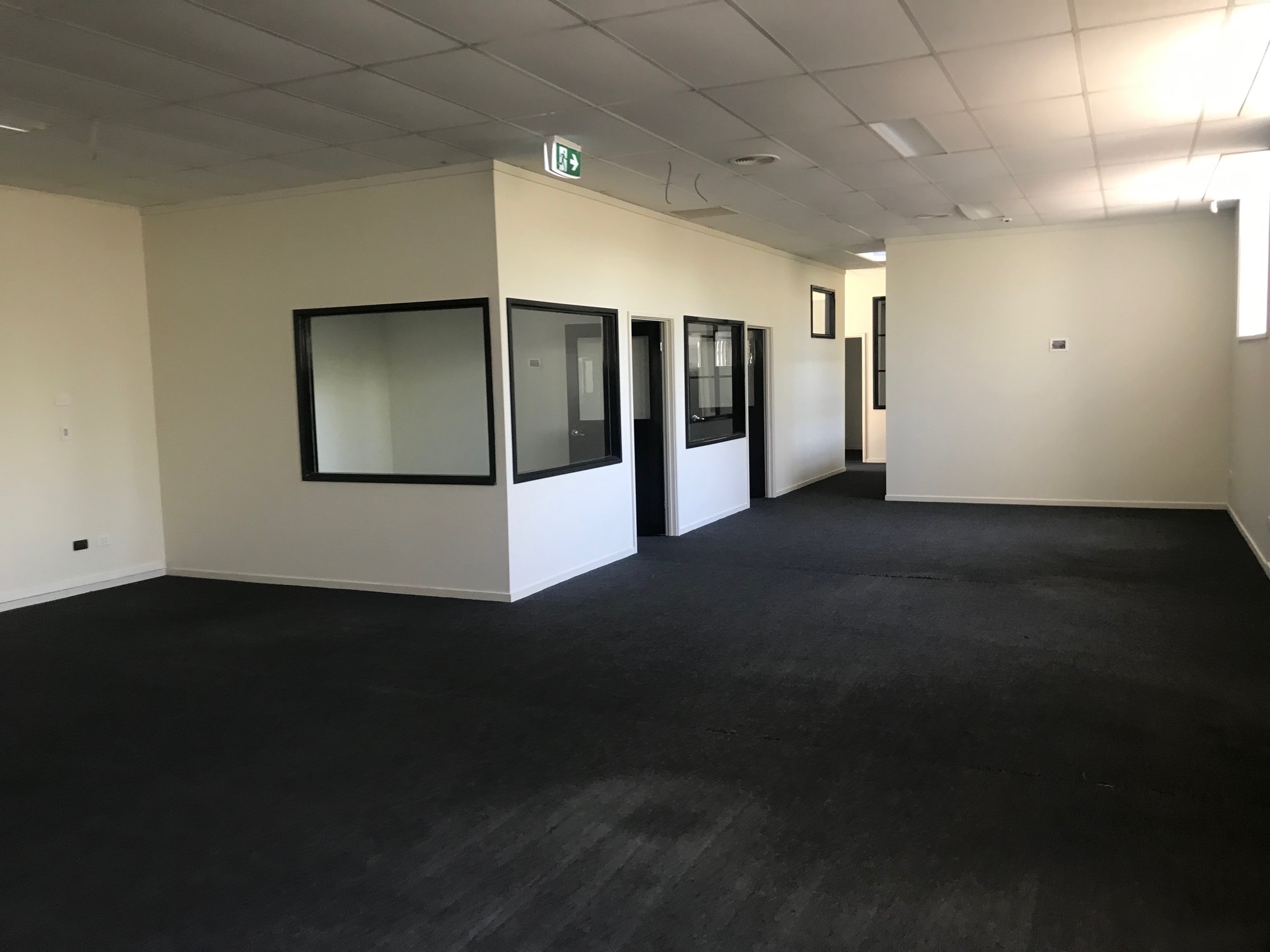 Small office space with dark carpets and white walls