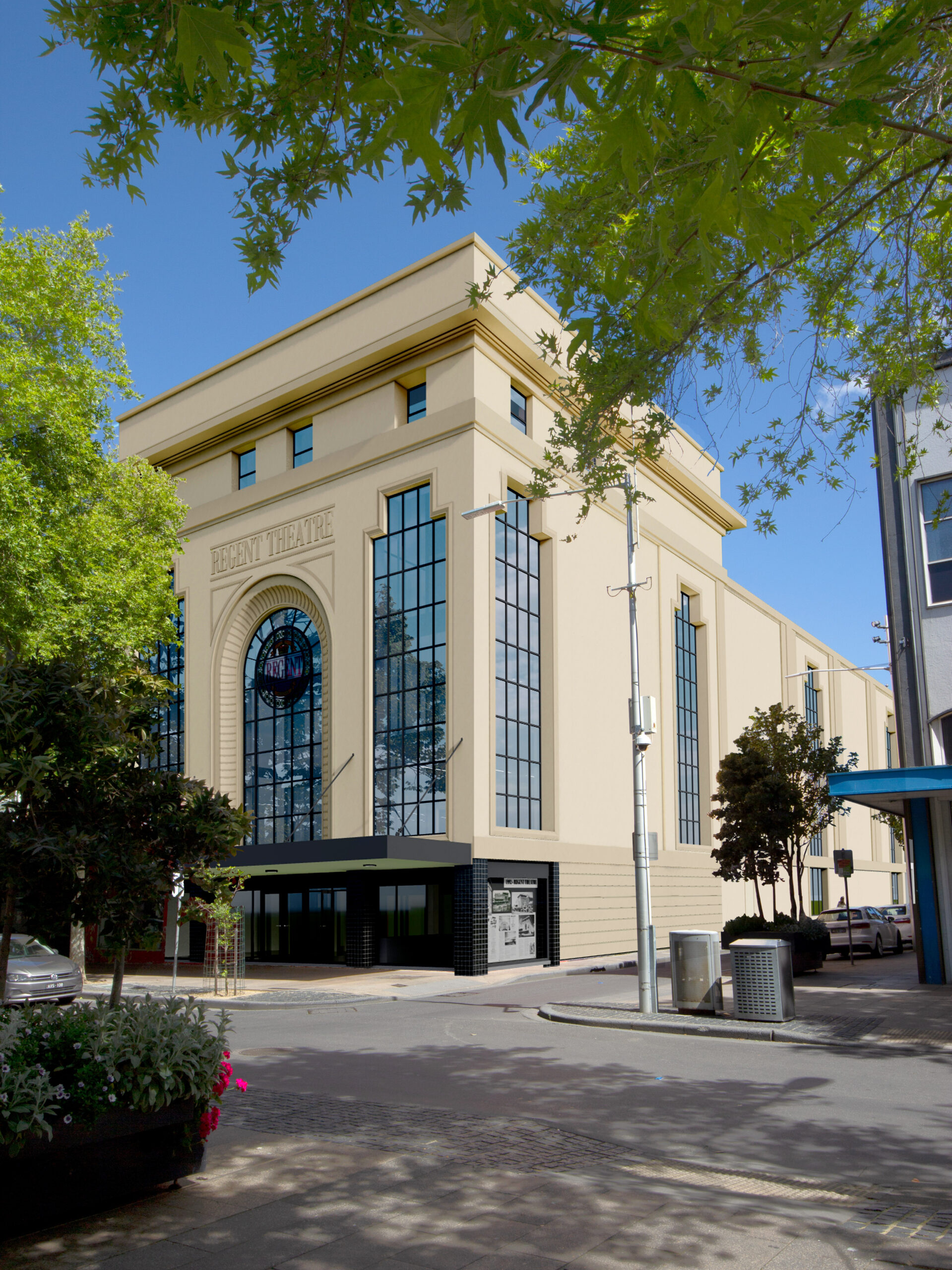 Artists concept render of future facade, outside street view of large yellow building, tall windows run up the side of the building, Sign with "regent theatre" on the front. Trees line the street and a clear blue sky above. Hamilton opportunities.
