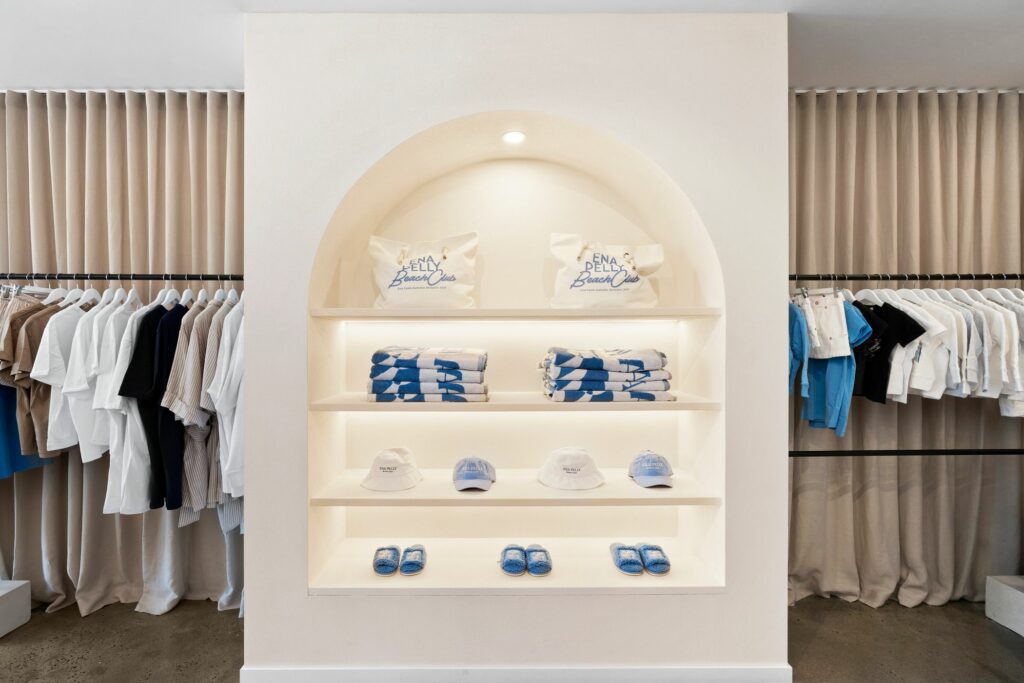 Beautiful aesthetically pleasing arch display nestled between floor to ceiling sheer curtains, designer clothing surrounds arch, well designed by Hamilton group