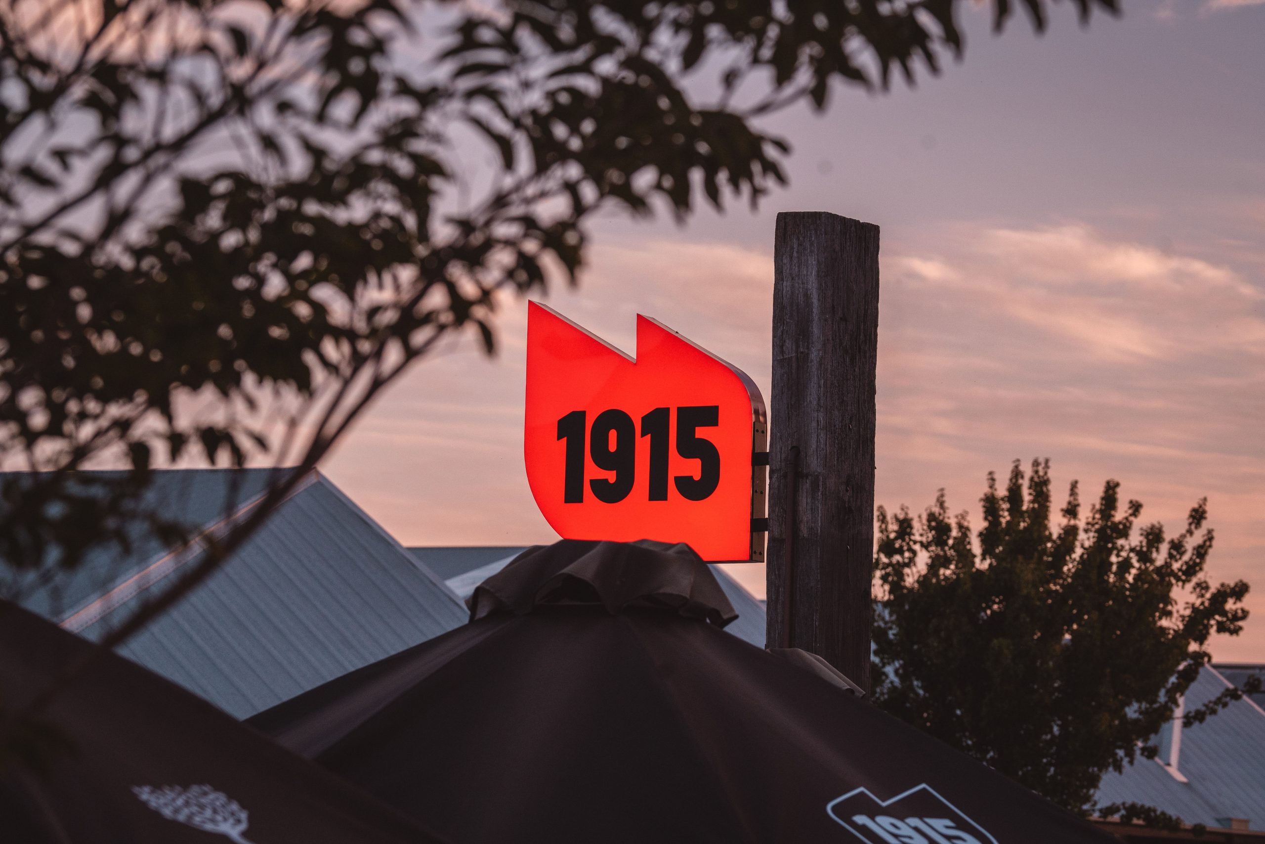 1915's illuminated red sign standing tall at dusk out the front of the restaurant