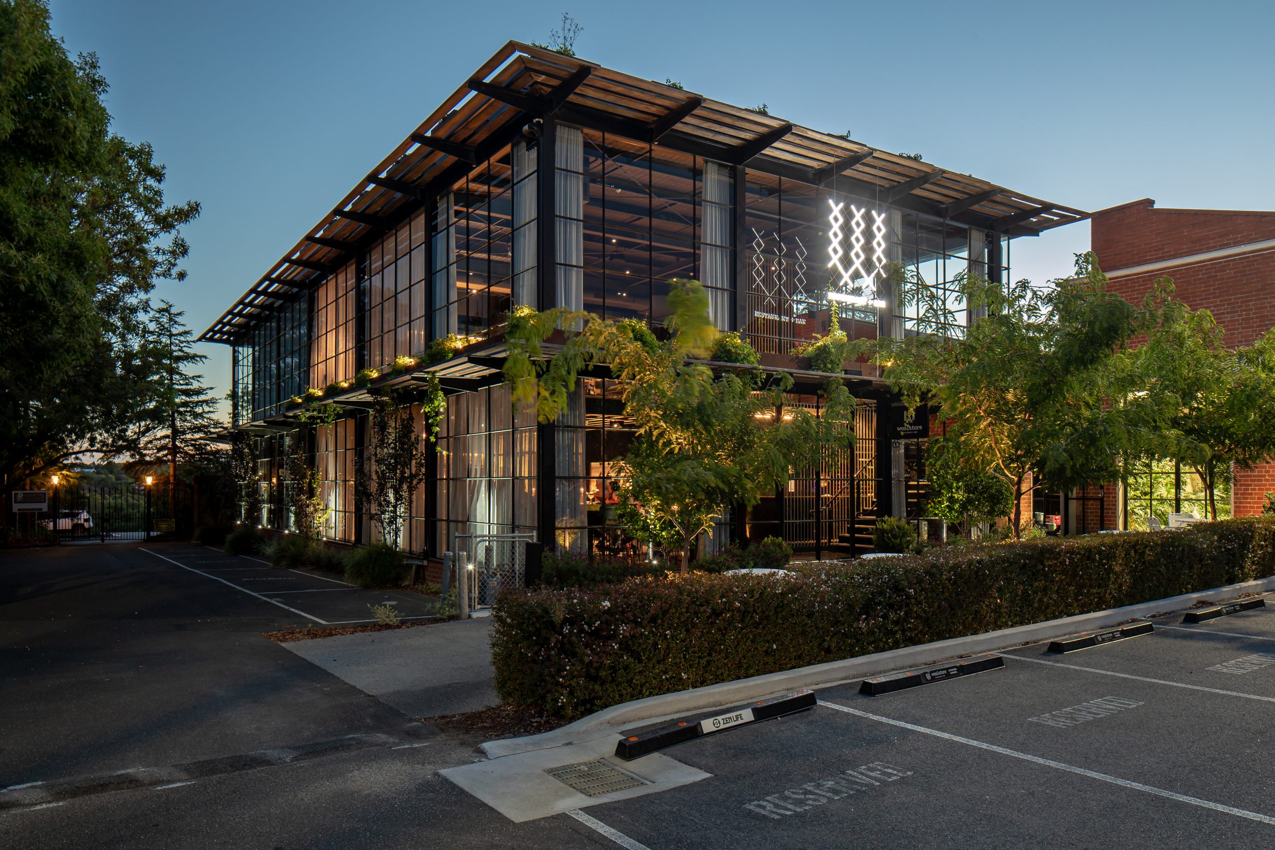 Geelong's best restaurant the Woolstore all lit up at night surrounded by lush green trees